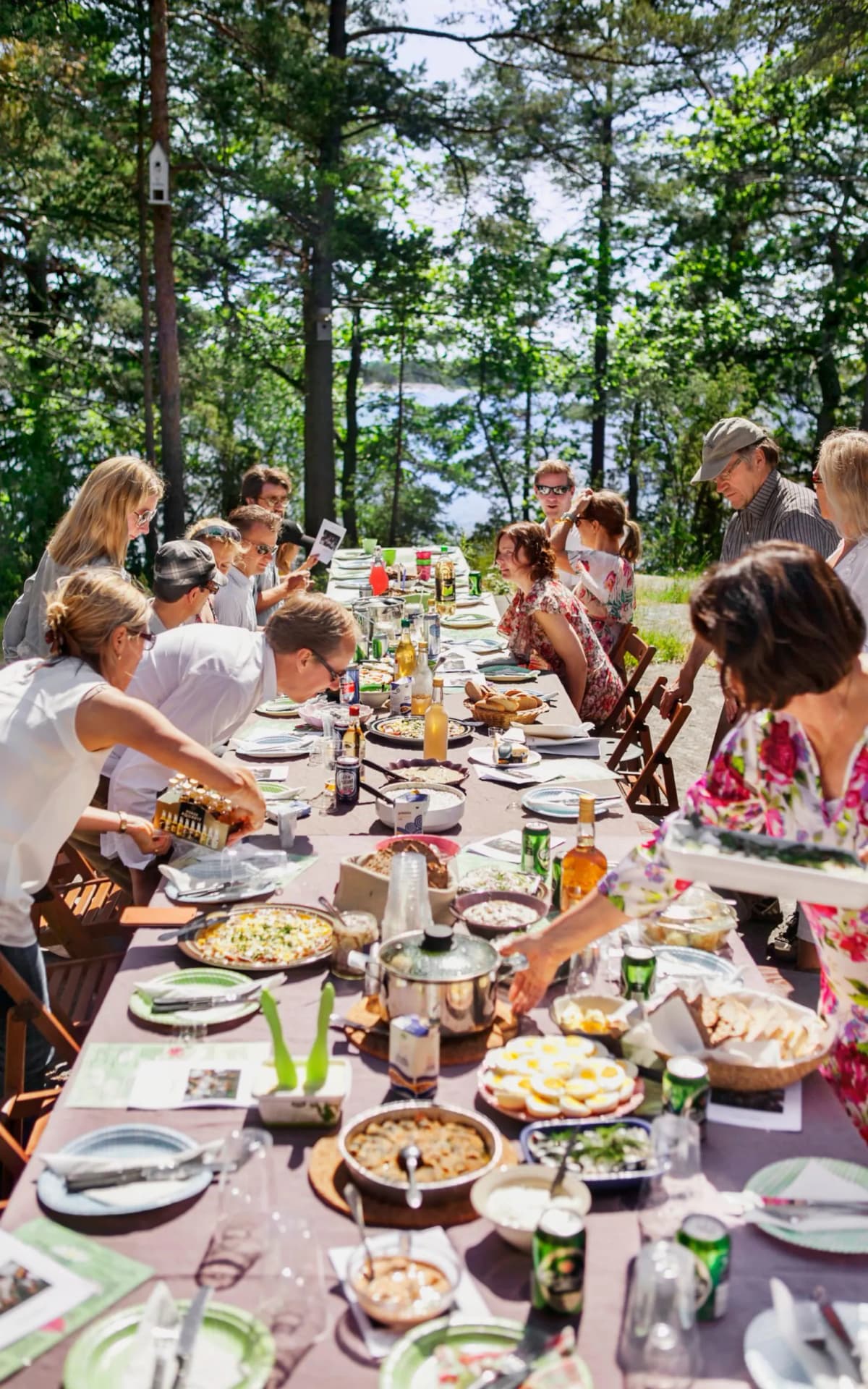 Uppdukat midsommarbord i skärgården med massa människor
